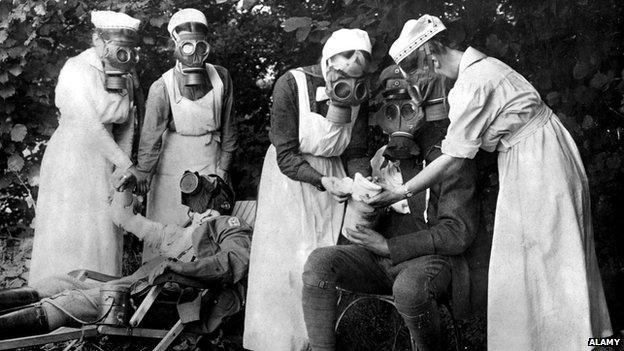 Nurses in gas masks treat soldiers afters a gas attack