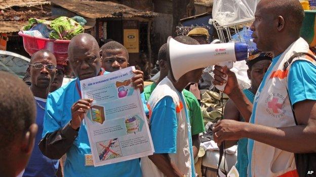 Health workers teach people about the Ebola virus and how to prevent infection, in Conakry, Guinea, Monday 31 March 2014