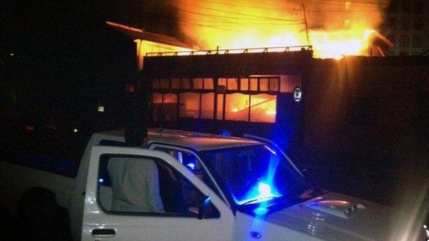 A man stares at a restaurant by the sea shore burning after a powerful earthquake hit Chile"s Pacific coast