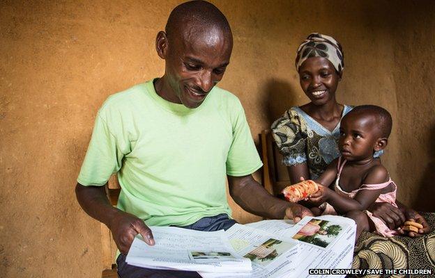 Flodouard, now 35, looks through the 1995 Save the Children case files of himself and his brother and sister