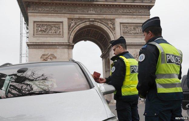 Paris police stop cars with even-numbered plates near the Arc de Triomphe (17 March)