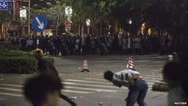 Demonstrators (front) throw bricks at riot police officers, as they protest against a chemical plant project, on a street in Maoming, Guangdong province, 31 March 2014