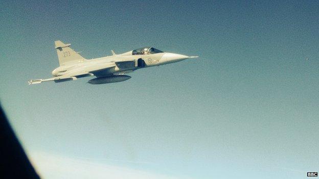 An F-15 pulls alongside the transport plane being ridden by our correspondent