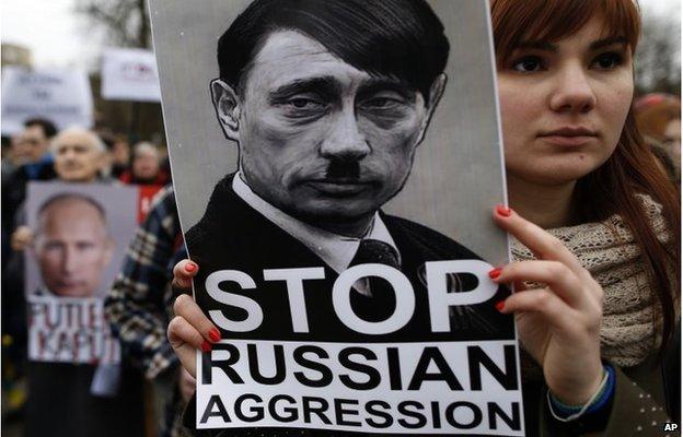 Demonstrator outside the Russian embassy in Vilnius holds up a sign saying "Stop Russian aggression"