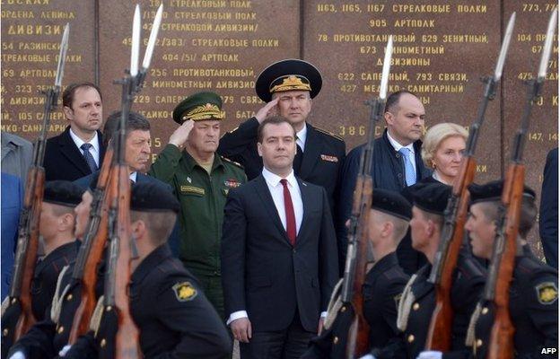 Russia's Prime Minister Dmitry Medvedev (back centre) watches Russian troops parading as he takes part in a wreath-laying ceremony at a World War Two memorial in Sevastopol, Crimea