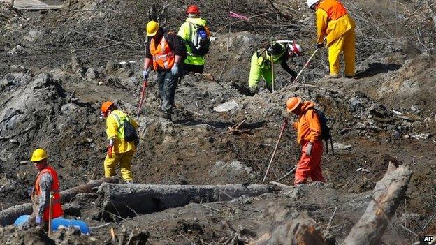 Workers dig at a much drier mudslide site on the west side at the west site of the mudslide on Highway 530 near mile marker 37, near Oso, Washington on 1 April 2014