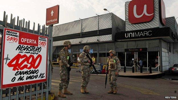 Soldiers guard a supermarket in Iquique on 2 April 2014