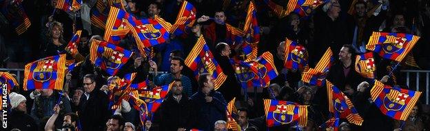 Barcelona fans wave their flags during the UEFA Champions League Quarter Final first leg match between FC Barcelona and Club Atletico de Madrid at Camp Nou on April 1, 2014.