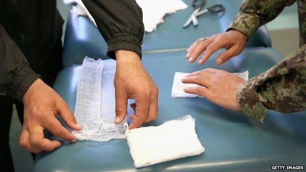 Afghan National Army (ANA) soldiers fold gauze into dressing pads in preparation for possible mass casualties due to election-day violence (2 April 2014)