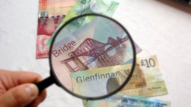 Scottish bank notes under magnifying glass