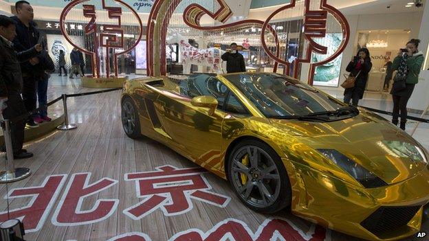 A gold Lamborghini luxury sports car is displayed at a mall with a price tag in Beijing, China, on 17 February 2014