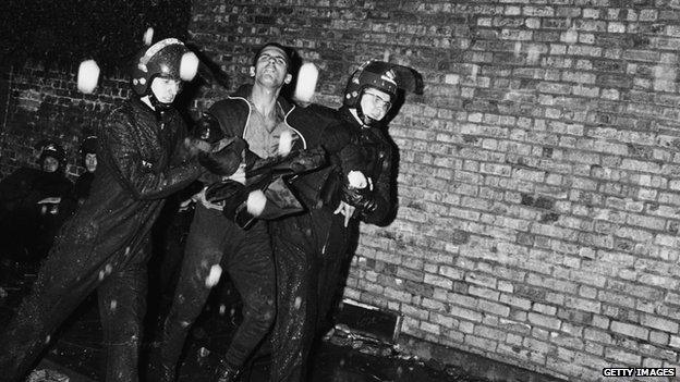 Man being arrested by officers during the riot