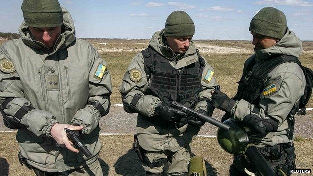 Ukrainian soldiers check pistols during military exhibition near settlement of Desna in Chernigov region.