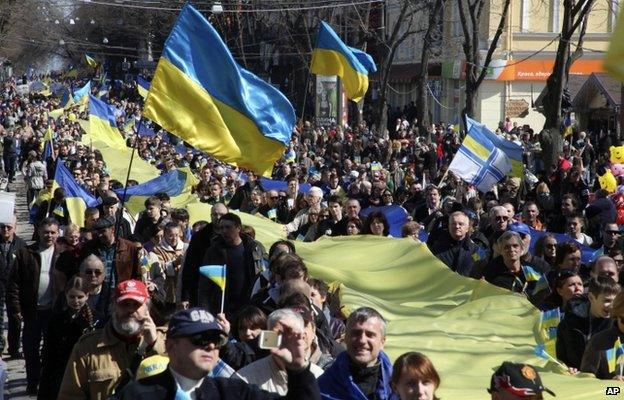 Demonstrators carry a huge Ukrainian national flag during an anti-war protest in the Black Sea port of in Odessa, Ukraine, Sunday, March 30, 2014.