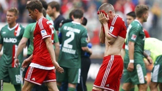 Bayern Munich's Bastian Schweinsteiger and Thomas Muller leave the pitch after their German Bundesliga match in Augsburg