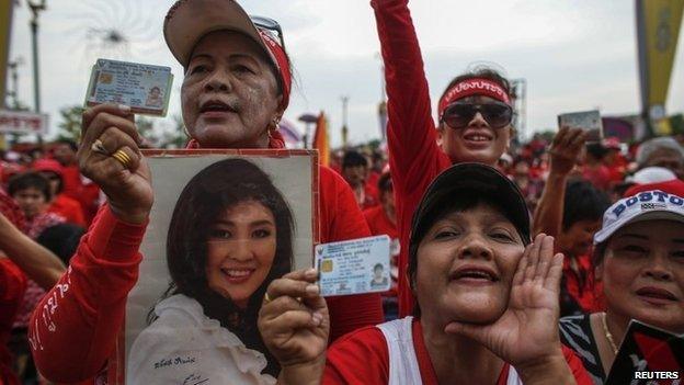 A member of the pro-government "red shirt" group holds a picture of Thailand's Prime Minister Yingluck Shinawatra during a rally on the outskirts of Bangkok, 5 April 2014