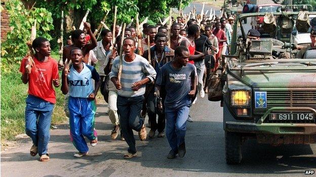 This file picture taken 27 June 1994 shows French soldiers on patrol passing ethnic Hutu troops from the Rwandan government forces, near Gisenyie.