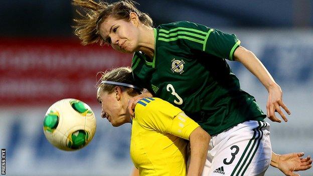 Sweden's Kosovare Asllani is beaten to the high ball by Lisa Armour