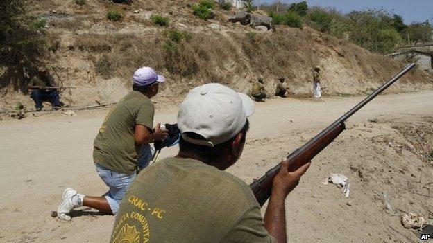 Community policemen take cover after being ambushed by gunmen near the town of La Concepcion on 4 April, 2014