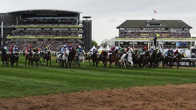 The starter waves his flag to signal a false start in the Grand National