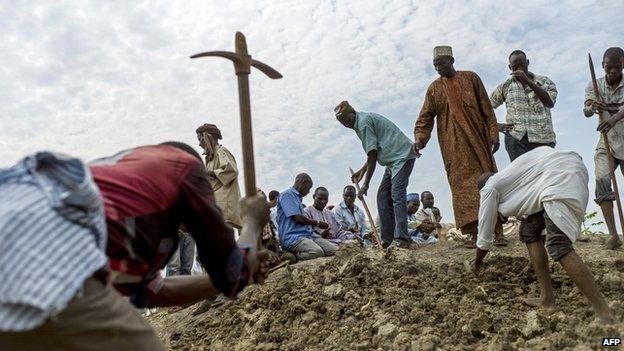 People dig as they bury 16 people in a Muslim cemetery in Bangui on 11 December 2013