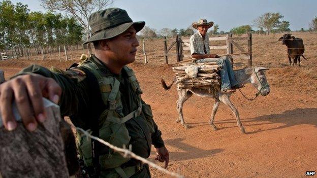 A policeman stands guard in Santa Paula's farm near Monteria, Cordoba department on 28 March, 2014