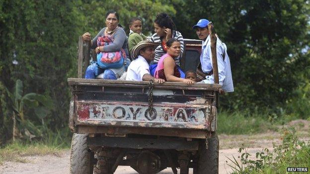 Coffee growers and their families, displaced by the conflict with Farc rebels, travel past a plantation in Serrania de Perija on 28 January, 2014