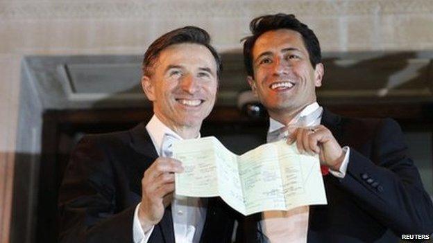 British couple Peter McGraith (L) and David Cabreza hold up their marriage certificate after their wedding in London last month