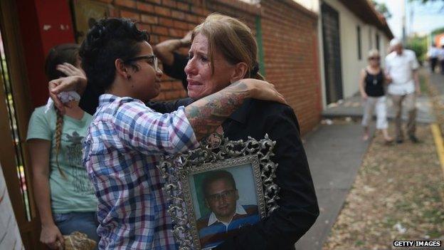 Carmen Gonzalez hugs a student protester following a mass for her son Jimmy Vargas on 7 March, 2014