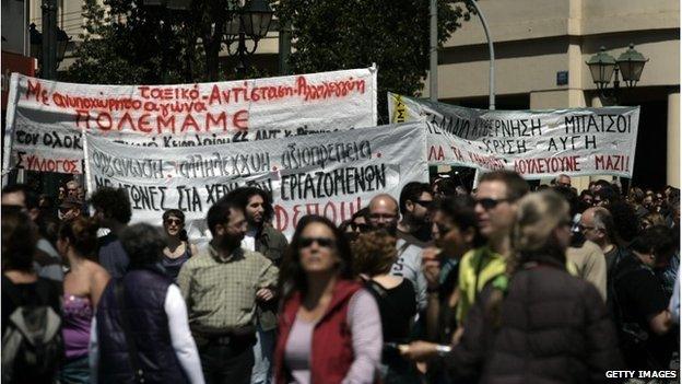 Protesters carry banners as they march towards Parliament during a labour strike on 09/04/14 in Athens, Greece.