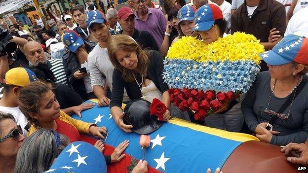 Relatives of Jimmy Vargas, a student who died during a recent protest, weep beside his coffin during his funeral in San Cristobal, 660 km from Caracas, February 26, 2014