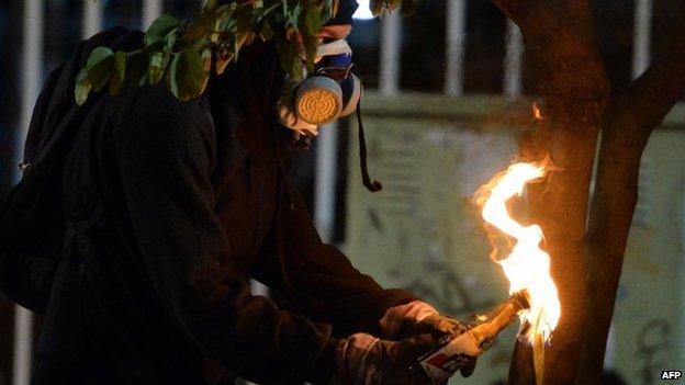 An anti-government activist gets ready to throw a Molotov cocktail during a protest in Caracas on 31 March, 2014