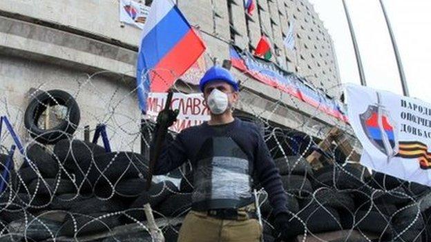 A pro-Russia protester guards a barricade outside the regional state administration building in Donetsk on 10 April