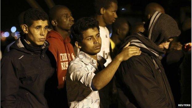 Migrants stand in line at the Sicilian harbour of Augusta April 9