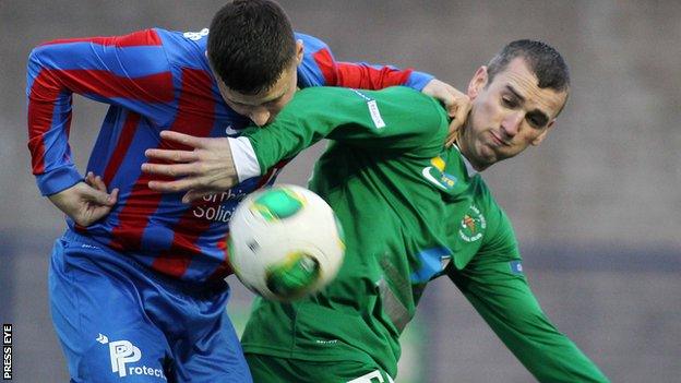 Adam Rogers of Ards challenges Ballinamallard's Ryan Campbell