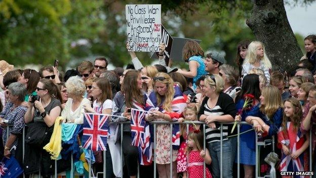 An anti-royal banner among the crowds of well-wishers