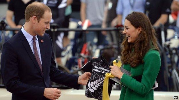 The Duke and Duchess of Cambridge holding a cycling jersey with Prince George's name on