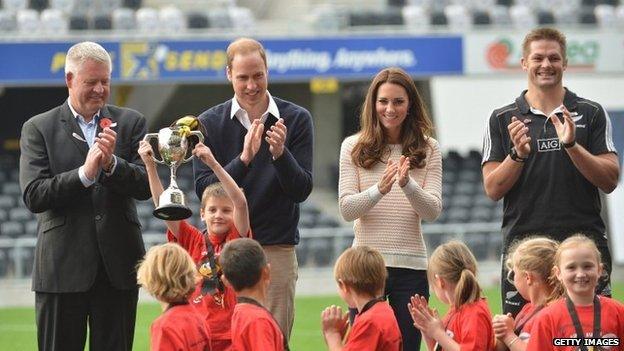 The winning tag rugby team lift the cup in front of the Duke and Duchess of Cambridge.