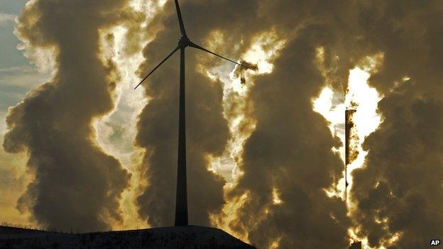 In this Dec. 6, 2010 file photo a wind turbine is pictured in the in front of a steaming coal power plant in Gelsenkirchen, Germany