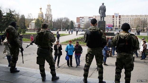 armed men stand guard