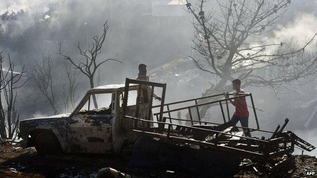 People try to salvage any useful material after a huge fire devastated an area of Valparaiso, on 14 April 2014