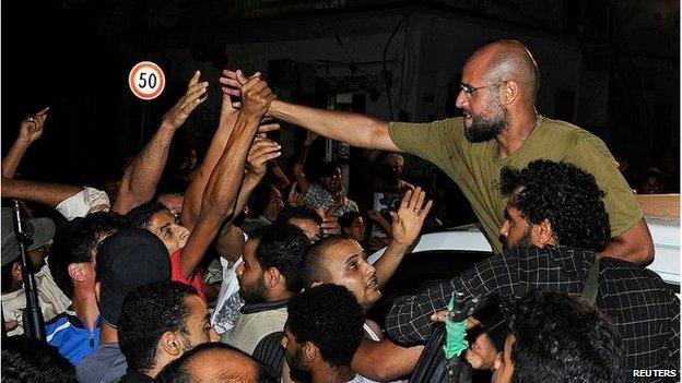 Saif Al-Islam Gaddafi greets supporters in Tripoli on 23 August 2011