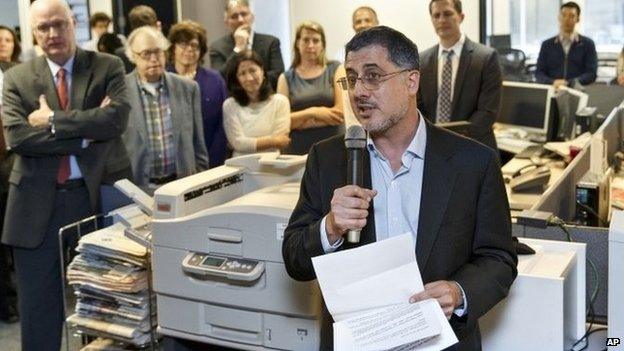 After the Pulitzer Prize for Public Service was awarded to The Washington Post, reporters and editors gather in the newsroom in Washington 14 April 2014