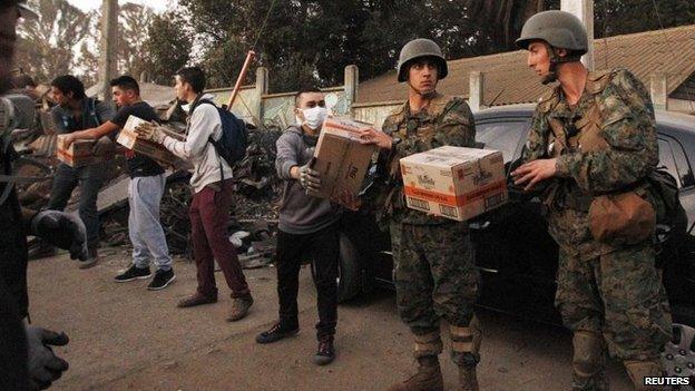 Soldiers (R) deliver food supplies to affected residents in Valparaiso, April 14, 2014.