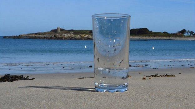 Glass of sea water at Ladies Bay, Guernsey