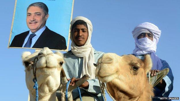 Supporters of ormer prime minister Ali Benflis hold up his image in Adrar, 1,400 km southwest of the capital Algiers