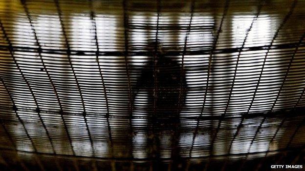 A prisoner at HMP Pentonville walks through an atrium May 19, 2003 in London