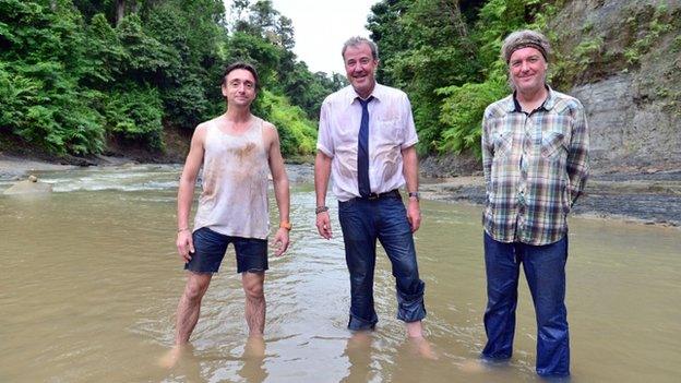 Richard Hammond, Jeremy Clarkson and James May stood in a muddy river