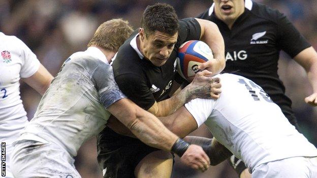 All Black fly-half Dan Carter takes on England's Manu Tuilagi and Tom Youngs