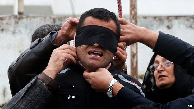 The mother (R) of Abdollah Hosseinzadeh removes the noose from around the neck of Balal, who killed her son, on 15 April 2014